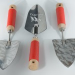 The Immigrant Crossing Sign is applied to three store bought steel trowels on a white background.