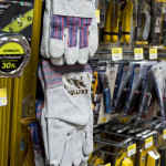 Work gloves that have been branded with the Immigrant Crossing Sign are placed back on the shelves of Home Depot.