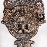 An assemblage sculpture of Catholic religious iconography and Mexican cultural iconography on white background.