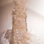 a cast lace white bronze metal wedding dress on a cream background with sateen under.